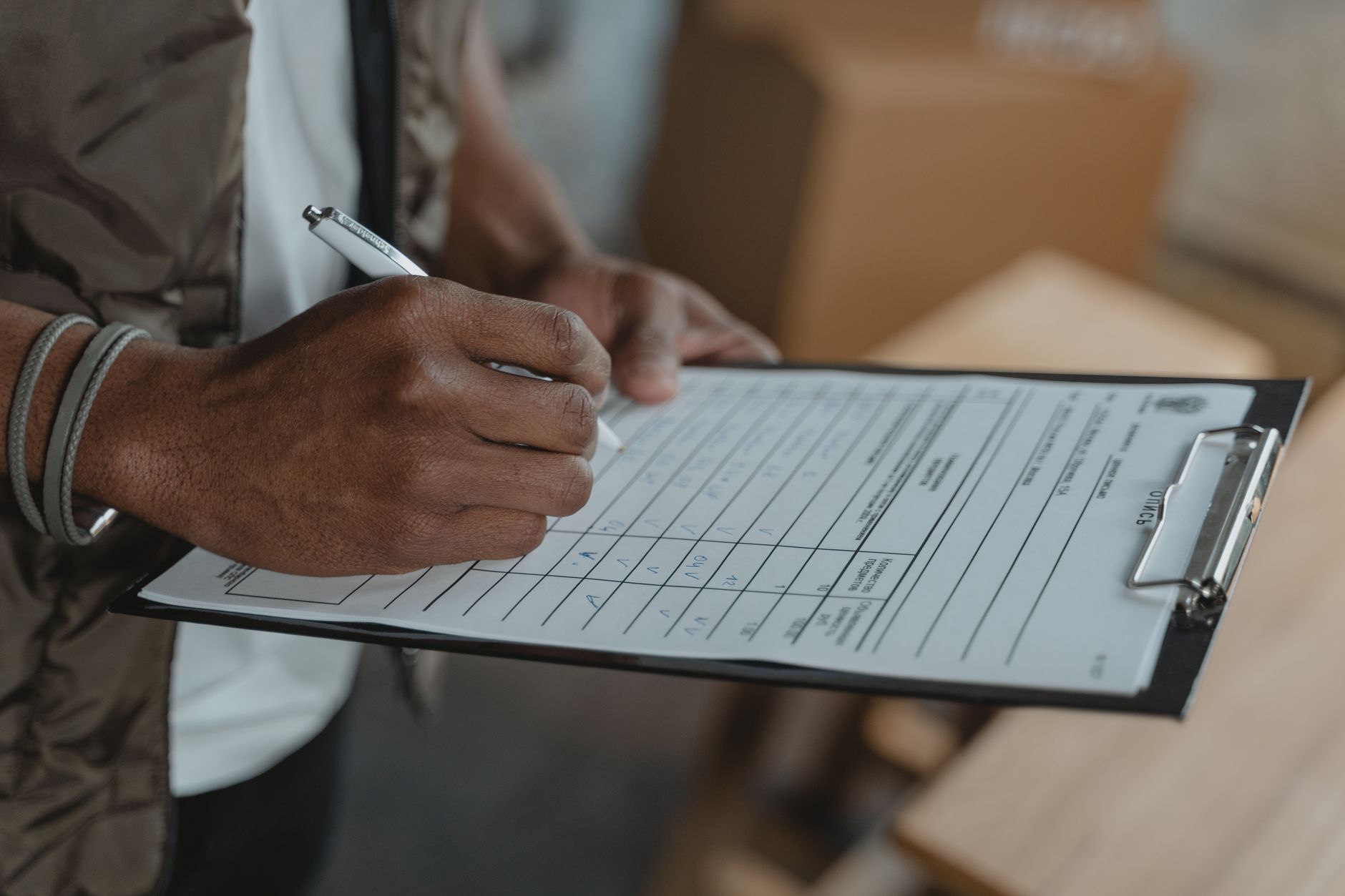 A person completing a checklist on a clipboard — the operational side of healthcare compliance