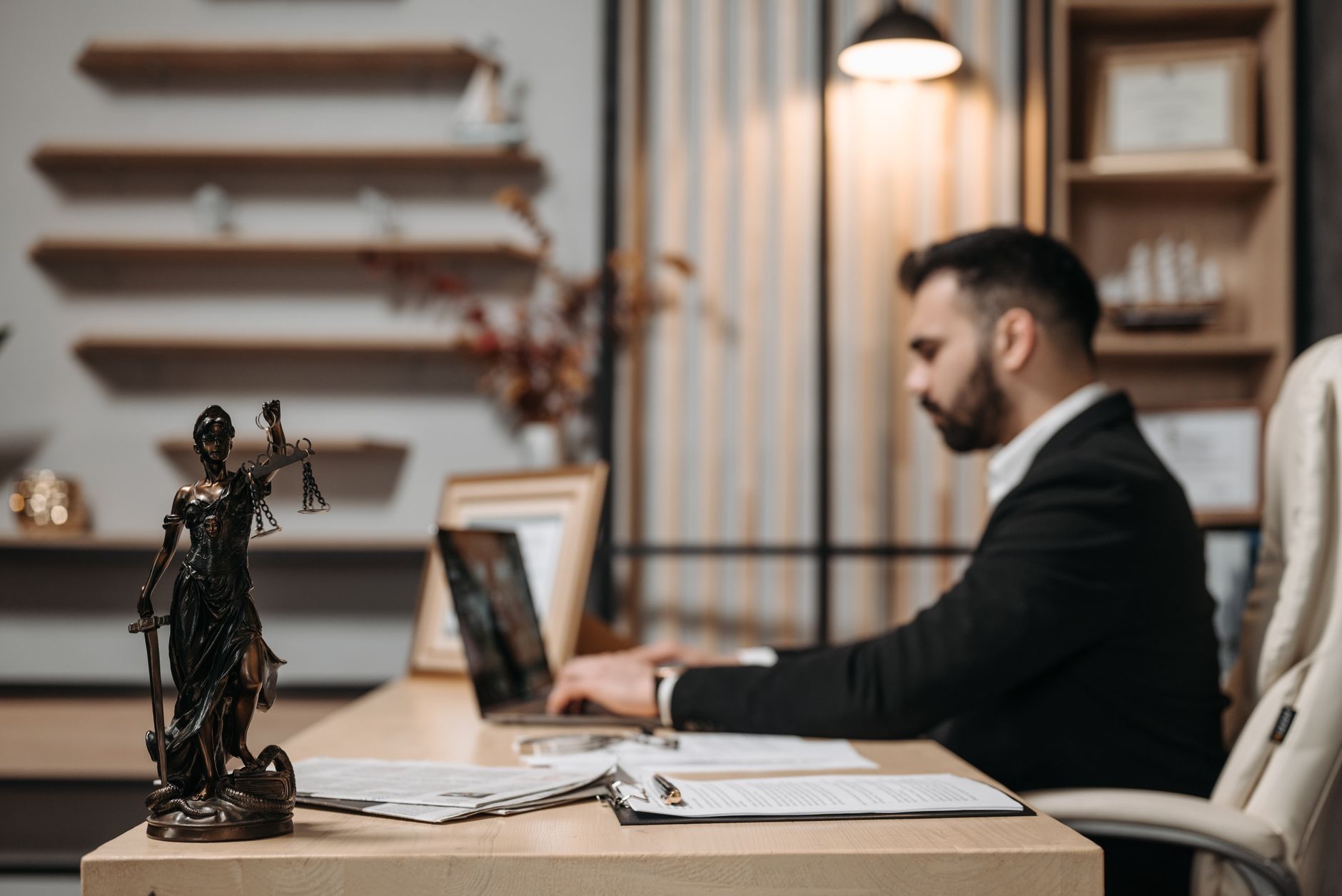 A lawyer working on a laptop at a desk in a modern office