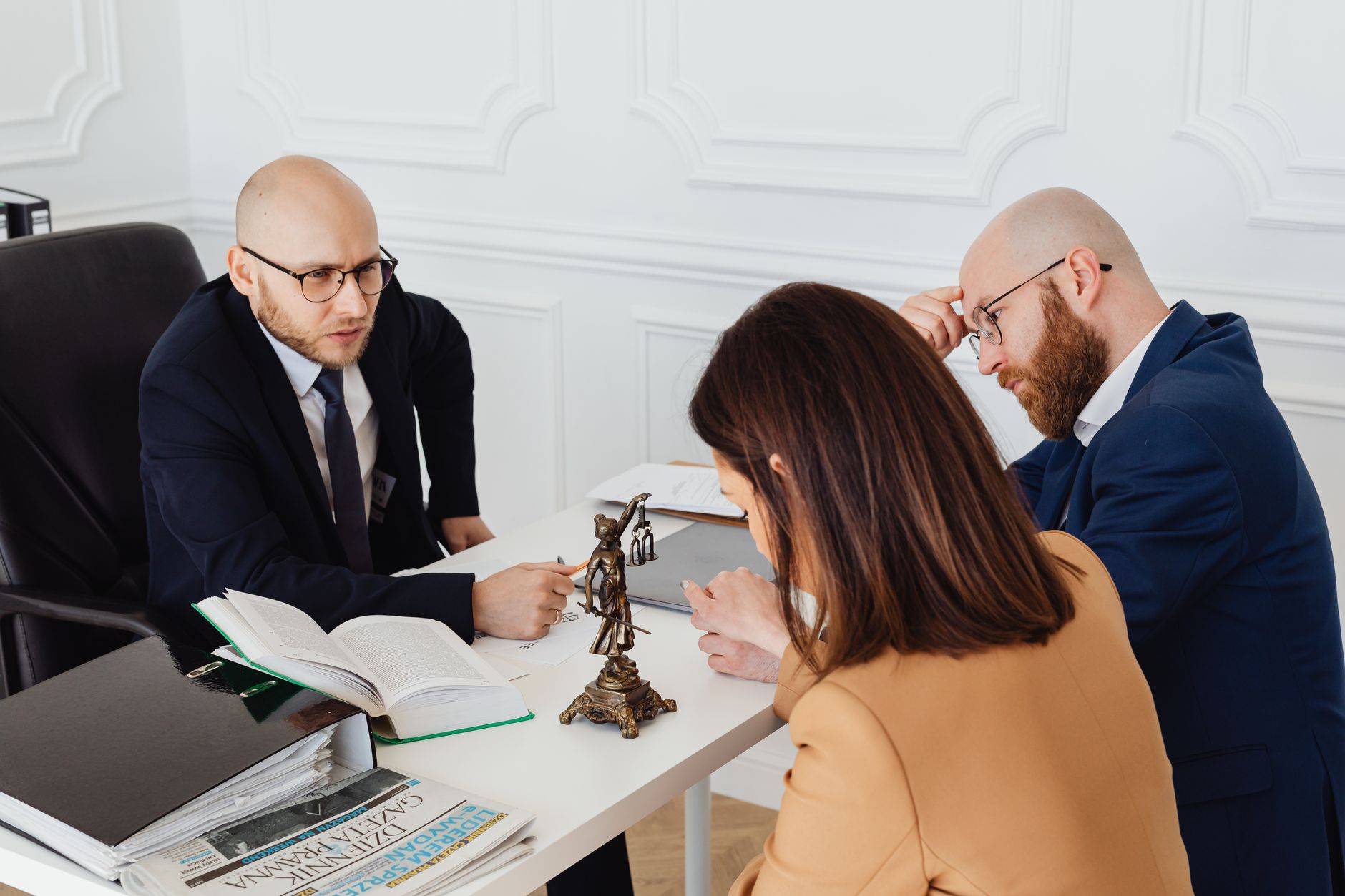 A lawyer meeting with clients across a table in a modern office.