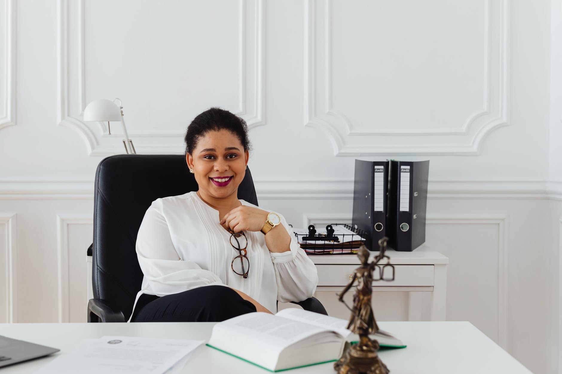A confident lawyer standing in a modern office with legal books.