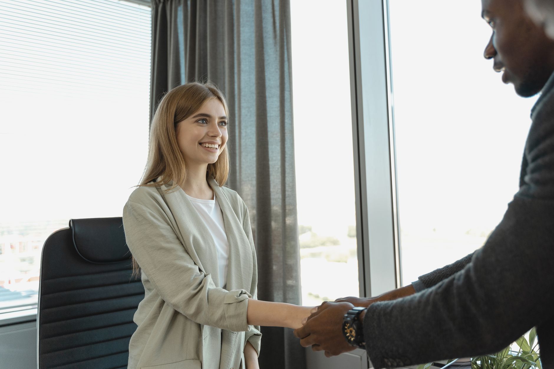 A lawyer shaking hands at a job interview in a modern office.