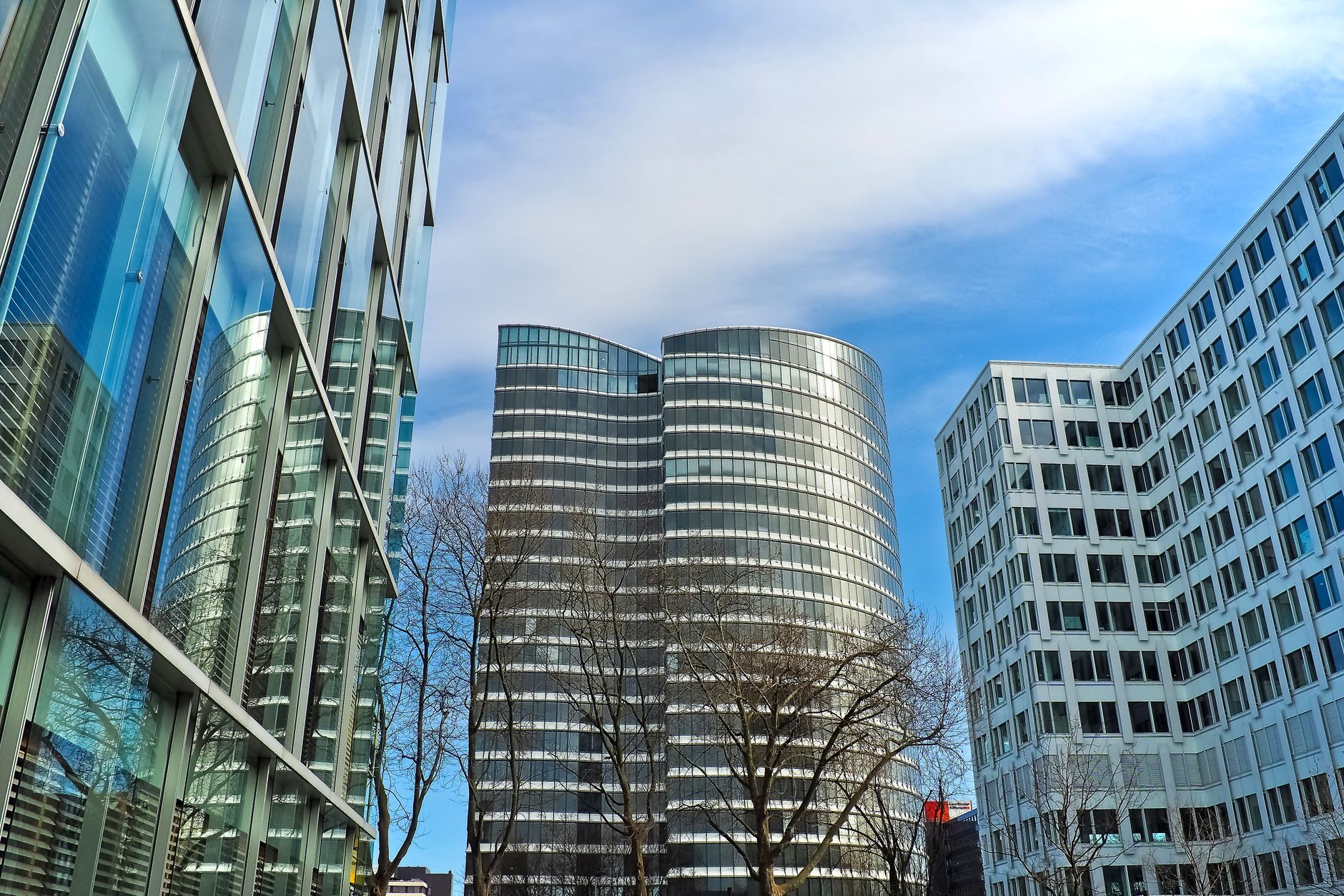 Modern corporate office towers against a blue sky.